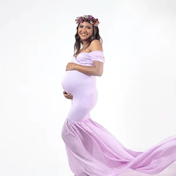 Chica embarazada con vestido lila en fondo blanco. Sesión de estudio